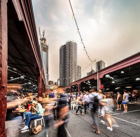 A group of people walking around Queen Victoria Markets in Melbourne's CBD